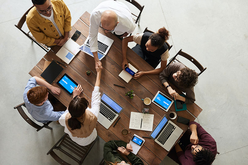 Photo taken from up top of a group of people meeting at a conference table