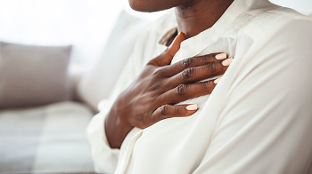 Photo of woman clutching her chest. (Photo by Getty Images)