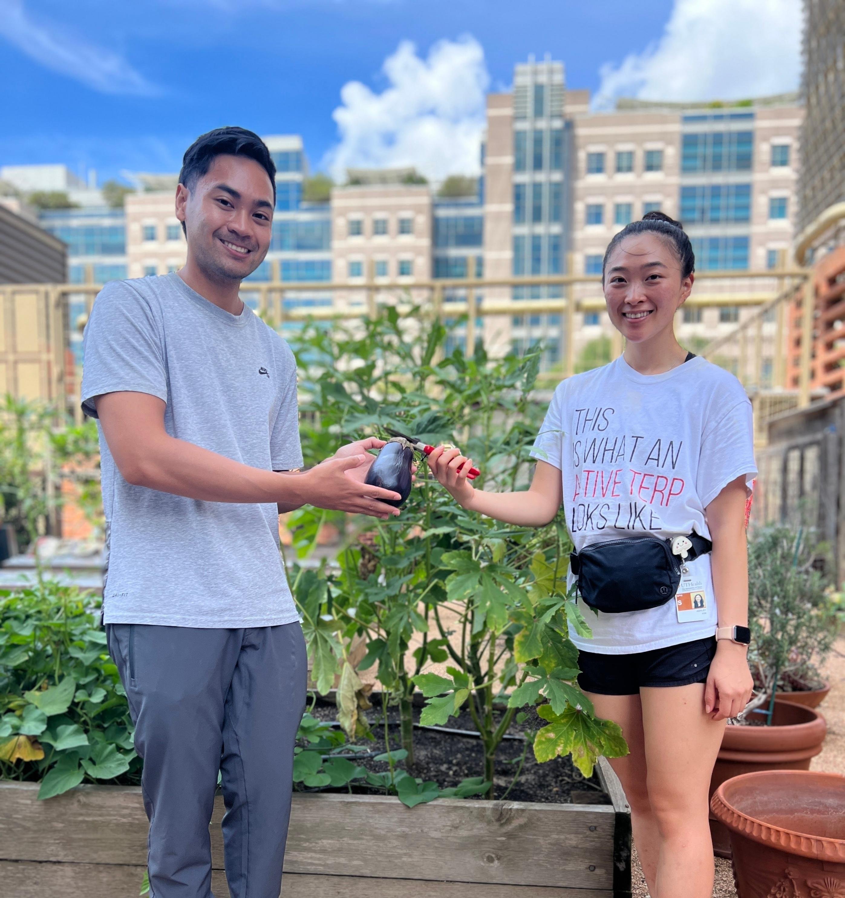 Dietetic Interns Martin Bombase (left) and Ashley Kim (right) Posing with Eggplant