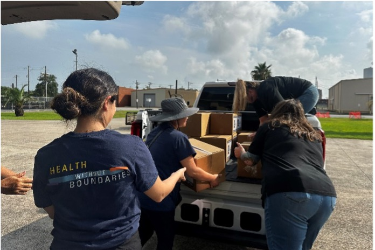 Volunteers unloading supplies from truck.