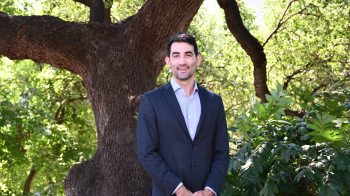 Kevin Lanza, PhD, shown infront of a tree