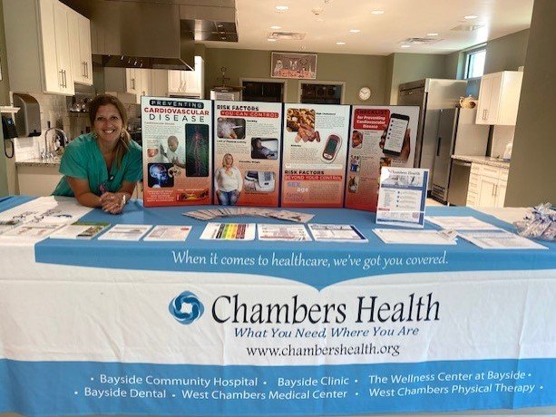 Health worker standing behind a table with a Chambers Health tablecloth