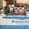 Health worker standing behind a table with a Chambers Health tablecloth