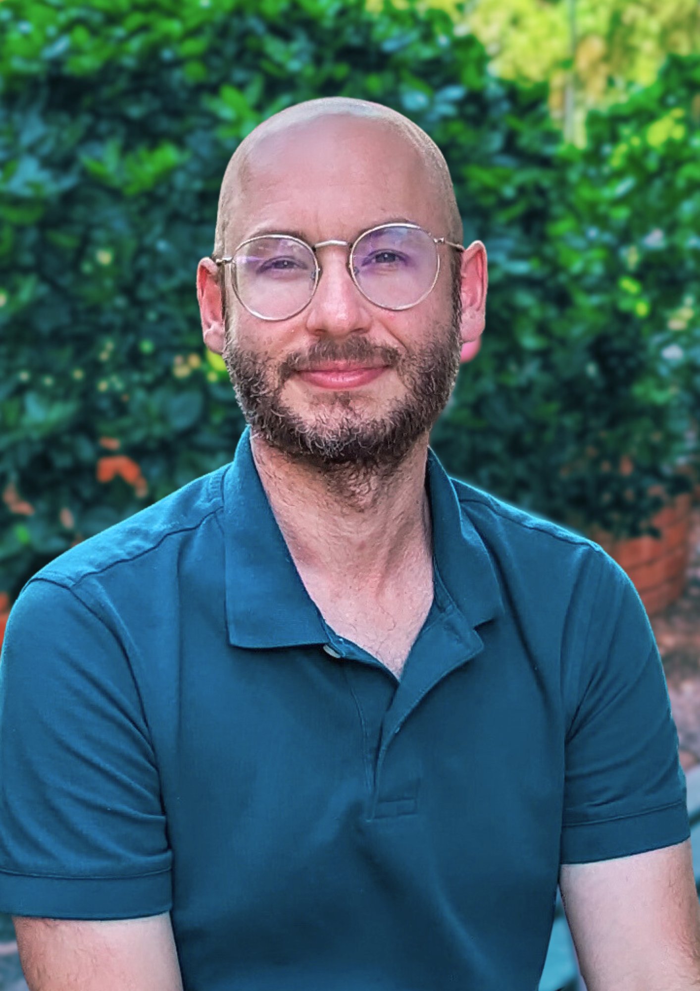 Student in front of greenery, posing for headshot.