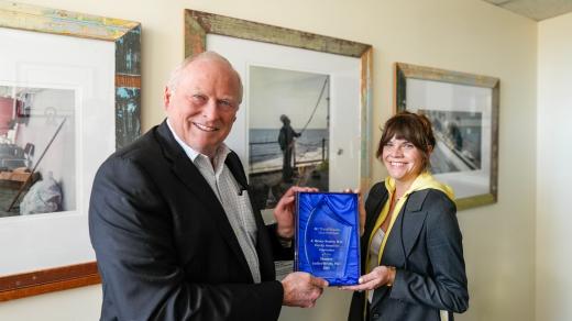 Eric Boerwinkle, PhD, dean of UTHealth Houston School of Public Health (left) presents Shannon Guillot-Wright, association professor (right) the Palmer Beasley Award