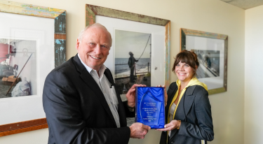 Eric Boerwinkle, PhD, dean of UTHealth Houston School of Public Health (left) presents Shannon Guillot-Wright, association professor (right) the Palmer Beasley Award