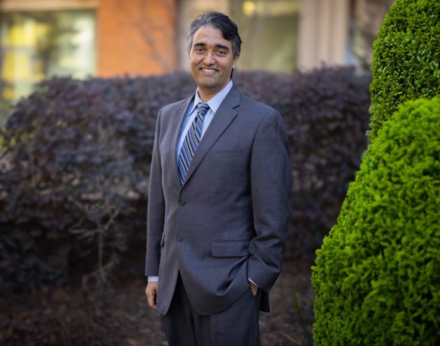 Aanand Naik pictured in front of greenery.