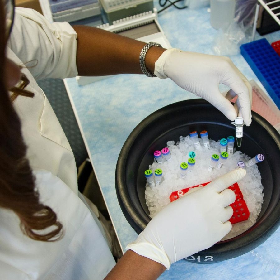 Lab researcher placing sample vials in an ice bucket (Photo: Unsplash)