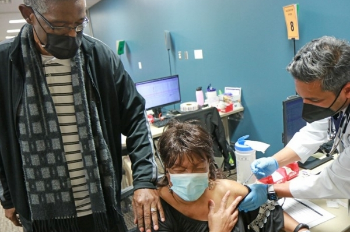 Dr. Nayak administers the COVID-19 vaccine to Janice Beecham. Photo provided by Parkland Hospital.