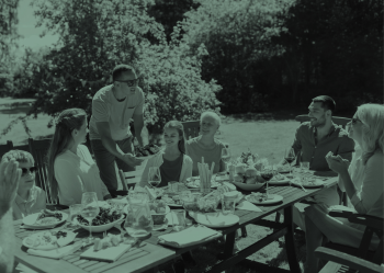 A family eats together in an outdoor picnic