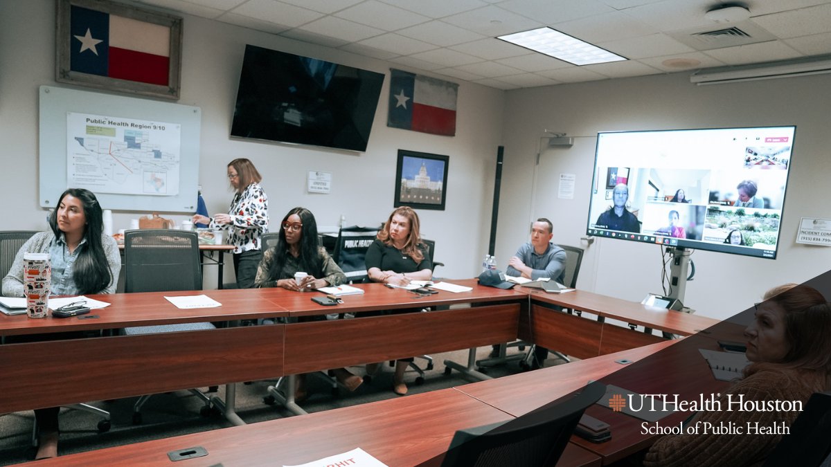 Picture of people sitting at conference table during meeting.