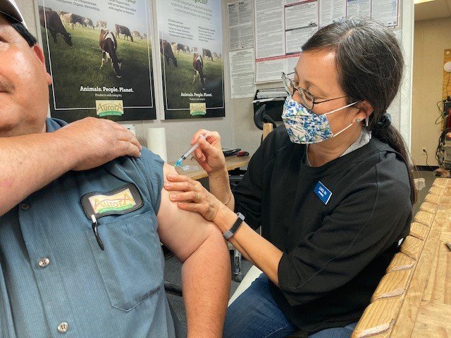 A TCU clinic partner vaccinates a farm worker