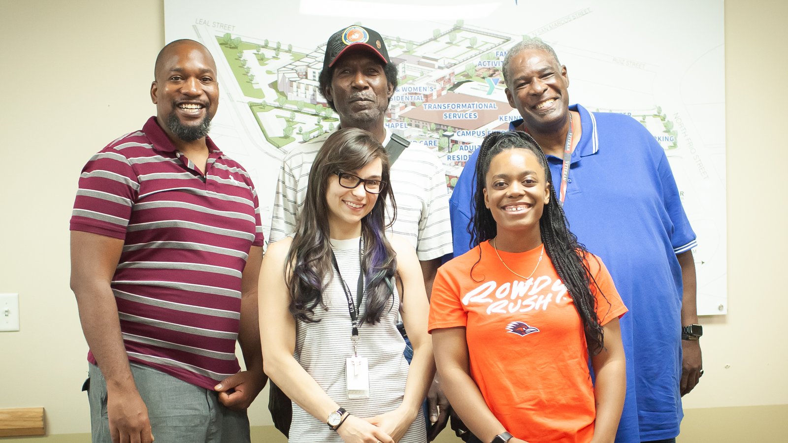 André Dixon, far right, poses with a group of formerly homeless veterans at the end of a money management training session with program manager and instructor, Katherine Kelton, front left.
