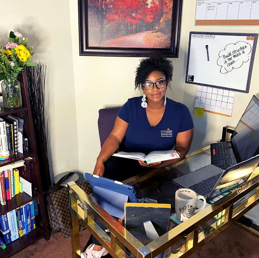 Bri sits in her home office, surrounded by books.