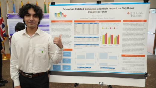 Arham Salman pictured in front of research poster.
