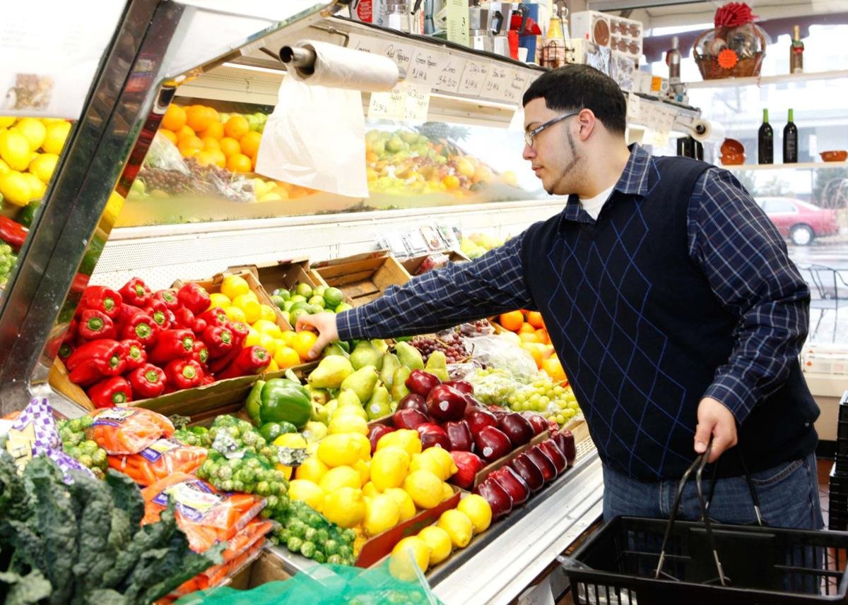 Man grabbing produce in a store.