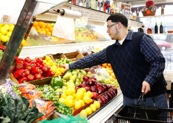 Man grabbing produce in a store.