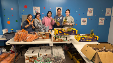 Senn and staff pictured at food bank in front of tables with groceries.