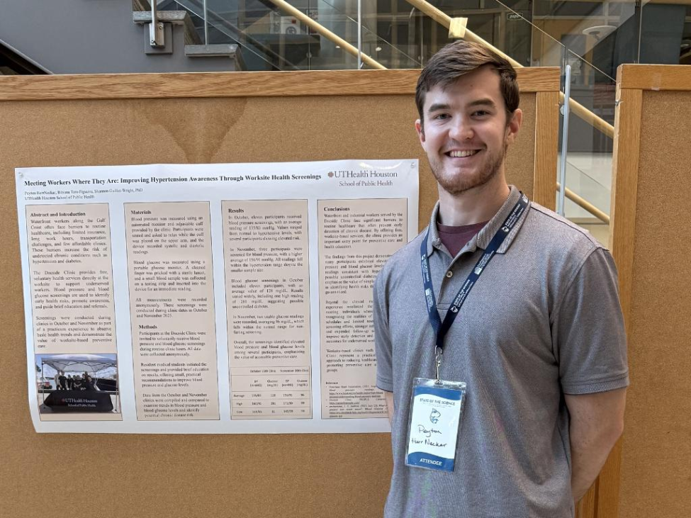 Peyton standing in front of research posters.