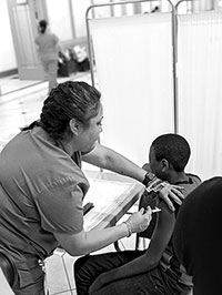 The nurse is giving a shot in the privacy screened area