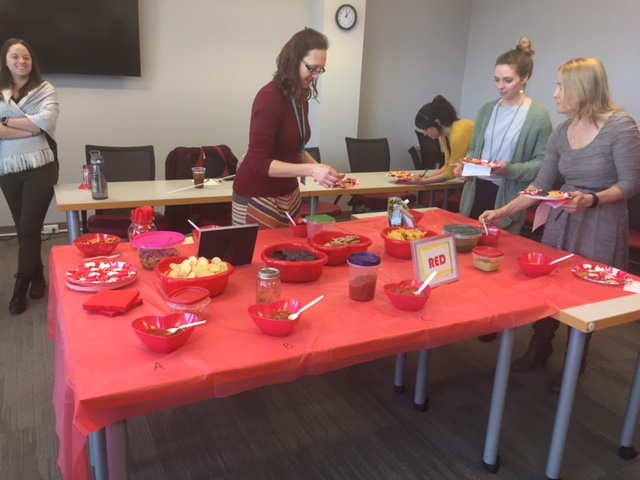 red table with hot sauce ingredients. people serving food.