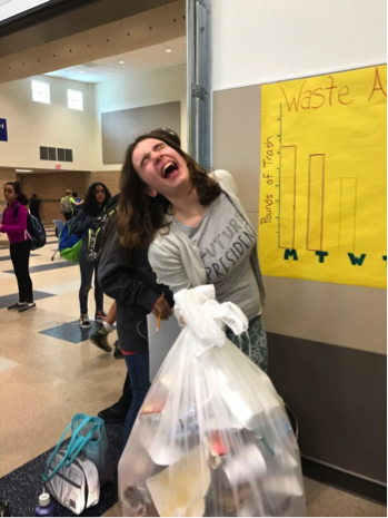 girl holding heavy trash bag