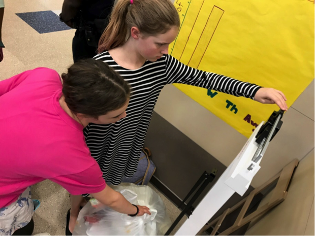 students reading poster about what can be composted