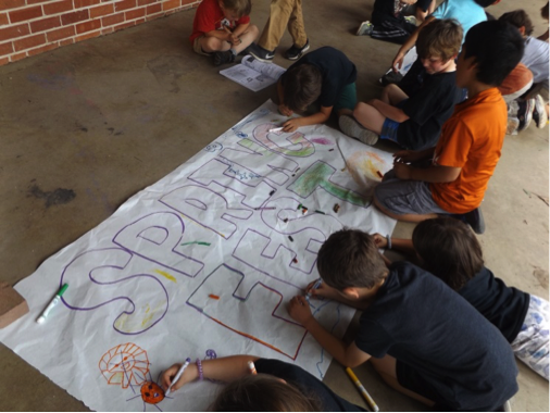 6 kids drawing a banner that says spring fest